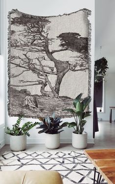 a living room with plants and a tapestry hanging on the wall