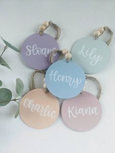 four wooden tags with names hanging from strings