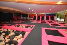 an indoor trampoline course with pink and black squares