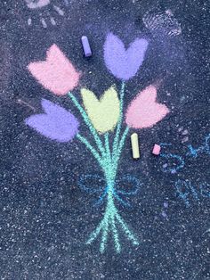 some chalk flowers and crayons on the ground