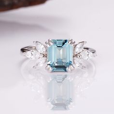 The gentle light blue color of our stunning, hand-chosen aquamarine is the perfect compliment to our gorgeous Ivy ring design. Each ring is made from premium sterling silver to add a little luxury and charm; meanwhile, we’ve included six gorgeous crystals to help every ring shine on any occasion. The perfect design to give your wardrobe a boost! ✦ DETAILS ✦✧ Handcrafted ✧ 2.0 Carat center stone✧ Aquamarine and crystals ✧ Sizes 3.75-11.25✧ This ring will arrive ready to gift in a Kherish Jewelry Elegant Aquamarine Birthstone Ring In White Gold, Elegant White Gold Aquamarine Birthstone Ring, Emerald Cut Light Blue Jewelry For Weddings, Light Blue Emerald Cut Jewelry For Wedding, Light Blue Emerald Cut Wedding Jewelry, Elegant Light Blue Birthstone Promise Ring, Elegant Light Blue Aquamarine Diamond Ring, Elegant Light Blue Rings With Prong Setting, Elegant Light Blue Sapphire Promise Ring