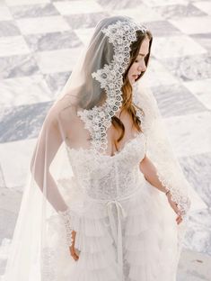 a woman in a wedding dress with a veil on her head