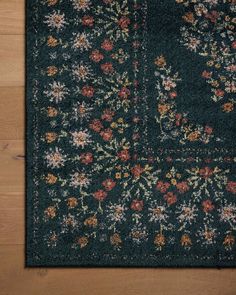 an area rug with flowers and leaves on the floor in front of a wood floor