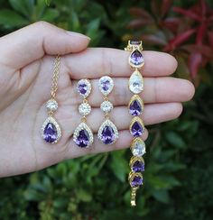 a person holding several pieces of jewelry in their hand, including an amethorate and diamond necklace