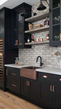 a kitchen with black cabinets and white counter tops, an open wine rack in the corner