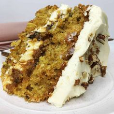 a piece of carrot cake with white frosting on a plate