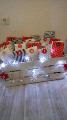 a wooden crate filled with christmas presents on top of a white tablecloth covered floor