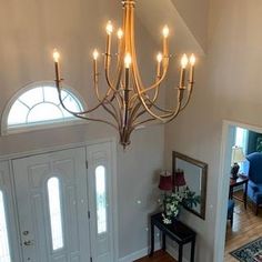 a chandelier hanging from the ceiling in a living room next to a door