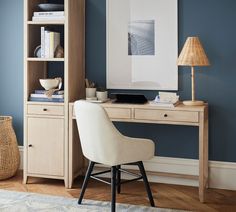 a white chair sitting in front of a desk with a book shelf on top of it