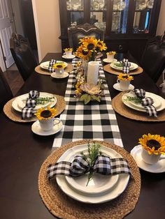 a dining room table set with sunflowers and place settings for the dinner table