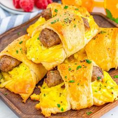 sausage and egg breakfast rolls on a wooden plate