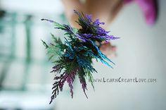 a person holding a purple and green plant in their hand