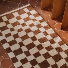 a brown and white checkered rug on the floor