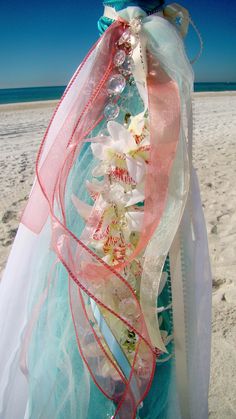 a woman wearing a blue and white dress on the beach