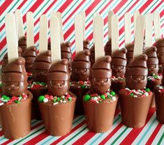 there are many chocolates in the cups with sticks sticking out of them and sprinkled with candy