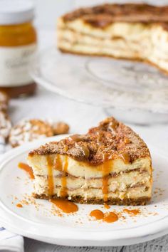 a piece of cake sitting on top of a white plate next to a jar of honey