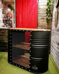 a large metal container sitting on top of a green floor next to a red door