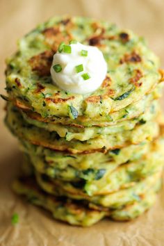 a stack of green pancakes topped with whipped cream