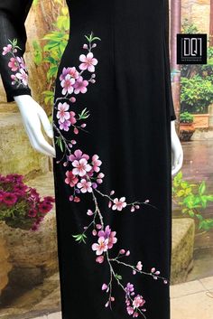 a woman's black dress with pink flowers painted on the front and back side