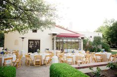 an outdoor dining area with tables and chairs set up for a formal dinner in the garden