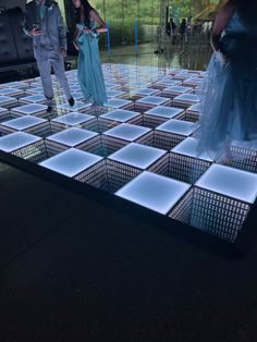 two people standing on a dance floor in front of a mirror with light up squares