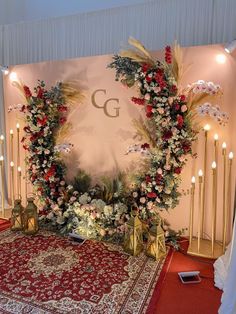 a decorated stage with flowers and candles on the floor for a wedding or special event