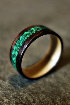 a wooden ring with green and brown wood inlays