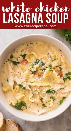 white chicken lasagna soup in a bowl with bread and parsley on the side