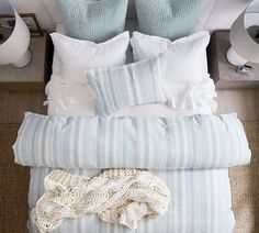 a bed with pillows and blankets on top of it