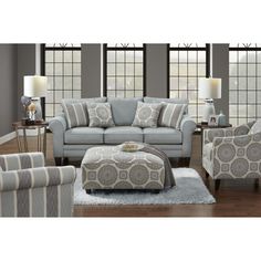 a living room scene with focus on the couch and chair, ottoman and footstool