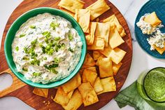 a bowl of dip surrounded by tortilla chips and avocado