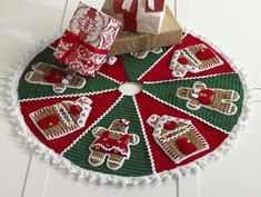 a knitted christmas tree skirt with presents on it