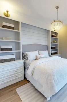 a white bed sitting in a bedroom on top of a hard wood floored floor