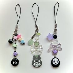 three key chains with charms attached to them on a white surface in the shape of animals