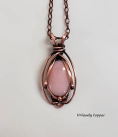 This stunning Peruvian pink opal cabochon has been wire wrapped in copper and is then antiqued, buffed and polished to a brilliant shine, and is clear coated to protect the antiqued finish. It comes with your desired length of copper chain and measures roughly 1 1/2 inches long and 7/8 inches wide, making it the perfect pendant size to add a touch of elegance to any outfit! Perfect as a wife gift for her for your 7th or 22nd Wedding Anniversaries, copper anniversary, or birthday gift!     Please Pink Wire Wrapped Copper Jewelry, Handmade Pink Copper Wire Jewelry, Pink Copper Wire Jewelry For Gifts, Handmade Pink Opal Jewelry Gift, Handmade Oval Rose Quartz Jewelry, Handmade Pink Opal Spiritual Jewelry, Copper Anniversary Gifts, Copper Anniversary, Copper Gifts