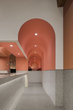 an empty bathroom with pink walls and white counter tops, along with a sink in the middle