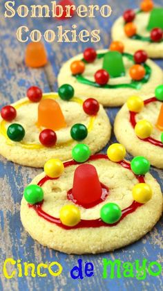 cookies decorated with gummy bears and candy are sitting on a blue wooden table top