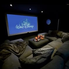 a movie theater with two couches and a projector screen in the middle of it