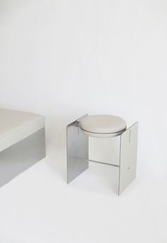 a white bench and stool are shown against a white background with no one in it