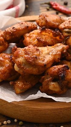 some chicken wings are on a wooden plate