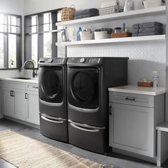 the front load washer and dryer are sitting next to each other in this kitchen