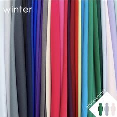 various colors of fabric hanging on a wall with the words winter written in white above them