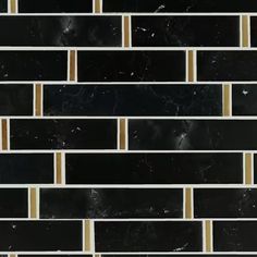 a black and white tile wall with gold lines on the bottom, in an angled pattern