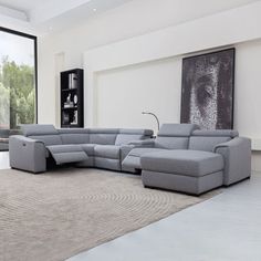 a modern living room with grey furniture and large windows