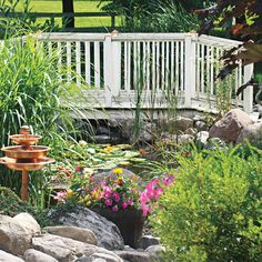 a garden with rocks, plants and a bridge