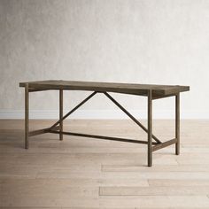 a wooden table sitting on top of a hard wood floor next to a white wall