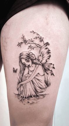 a woman's thigh with an angel tattoo on it