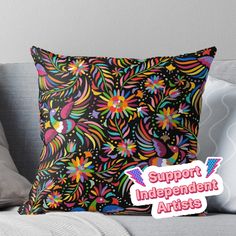 a pillow with the words support independent artists on it and an image of flowers in bright colors