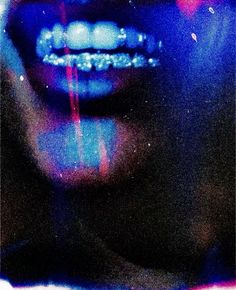 a woman's face with blue, pink and purple light coming from her mouth