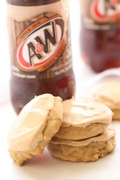 peanut butter and jelly sandwich cookies next to a bottle of beer on a white surface